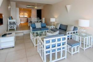 ein Wohnzimmer mit einem Sofa, Stühlen und einem Tisch in der Unterkunft 601 The Bermudas 3 bedroom beachfront Umhlanga Rocks in Durban