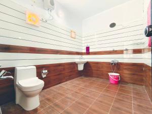 a bathroom with a toilet and a sink and a bucket at MARARI CASA LINDA HOMESTAY in Mararikulam
