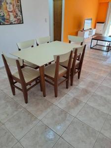 una mesa y sillas con una mesa blanca y una mesa y sillas en Amplio depto Mogotes en Mar del Plata
