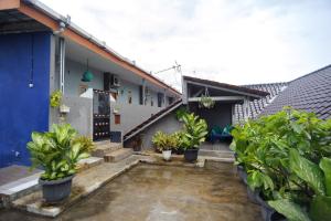 a courtyard with potted plants in front of a house at RedDoorz Syariah near RS Advent Bandar Lampung in Bandar Lampung