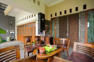 a living room with wooden chairs and a table at RedDoorz Syariah near RS Advent Bandar Lampung in Bandar Lampung