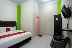 a bedroom with a bed and a tv in it at RedDoorz Syariah near RS Advent Bandar Lampung in Bandar Lampung