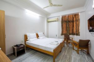 Rúm í herbergi á Sri Aarvee Hotels