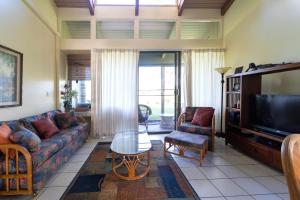 - un salon avec un canapé et une télévision dans l'établissement Hanalei Condo, à Kahuku
