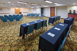 una sala de conferencias con mesas azules y sillas. en Tulsa Square Hotel Central, I-44 By OYO en Tulsa