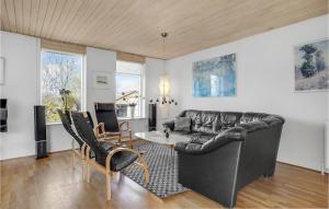 ein Wohnzimmer mit einem Ledersofa und einem Tisch in der Unterkunft Awesome Home In rsted With Outdoor Swimming Pool in Ørsted