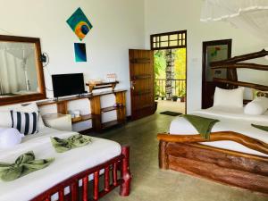 a room with two beds and a television in it at Ella River Front in Ella