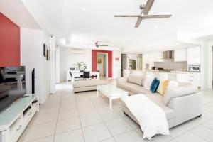 sala de estar con muebles blancos y cocina en Cairns Beaches Home, Marina View, Sleeps 12 en Yorkeys Knob