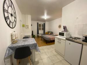 uma cozinha e sala de estar com uma mesa e um micro-ondas em Studio chaleureux Centre Ville em Excideuil