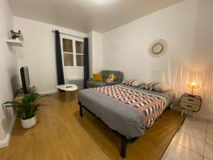 a bedroom with a bed and a couch at Studio chaleureux Centre Ville in Excideuil