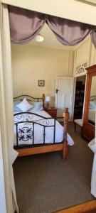 a bedroom with a bed with a canopy at Amiens Cottage. Queenslander, charming, central. in Stanthorpe