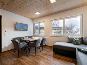 a living room with a couch and a table and chairs at Appartement Musik-Neureiter in Söll