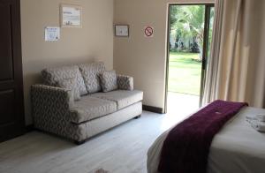 a living room with a couch and a chair at Heimat Guesthouse in Welkom