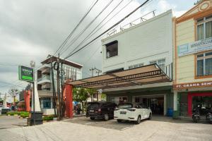Tanjungkarang的住宿－Urbanview Hotel Bong Gajah Lampung，一条在大楼前停放汽车的街道