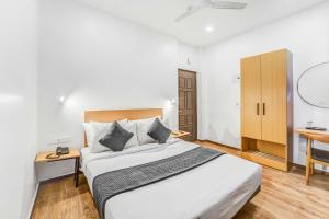 a bedroom with a bed and a desk and a mirror at Rohaan Inn - UPAR Hotels Ashok Nagar in Chennai