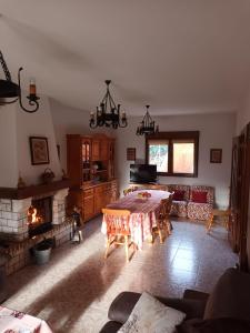 a living room with a table and a fireplace at Casa Rural Las Canales in Zapardiel de la Ribera