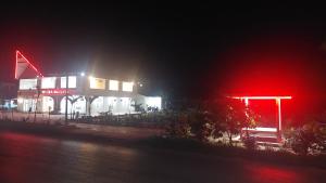 a building lit up at night with red lights at Hotel Wisma Mangurna in Doloksanggul