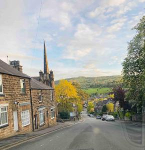 an empty street in a small town with a church at The studio (Hideaway) Dog friendly in Matlock