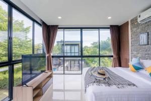 a bedroom with a large bed with a large window at Star Stay Pool Villa @ Pattaya พัทยา in Ban Huai Yai