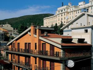 an orange building with a balcony in a city at Hotel Colonne in San Giovanni Rotondo