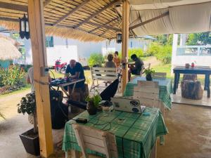 a group of people sitting at tables under an umbrella at Blue Sky Resort in Ko Chang