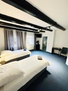 ein Hotelzimmer mit 2 Betten und einem Schreibtisch in der Unterkunft Löwen Unterkunft Braunschweig in Braunschweig