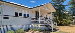 a small white house with a white fence at Amiens Cottage, historic, quiet, in heart of Stanthorpe in Stanthorpe
