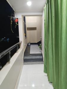 a hallway with a green curtain and a television at Deep Home stay in Agartala
