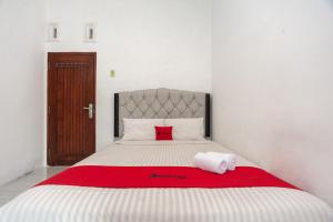 ein Schlafzimmer mit einem großen Bett mit einer roten Decke in der Unterkunft RedDoorz Syariah @ Jalan Panglima Polim Lampung in Lampung