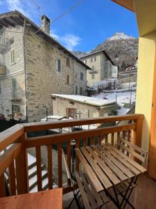 un banco de madera sentado en el balcón de un edificio en APPARTAMENTO PRIMOLO - CHIESA IN VALMALENCO, en Chiesa in Valmalenco