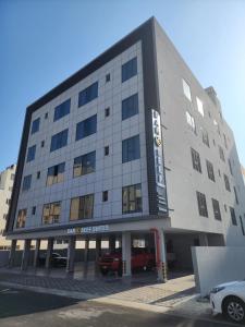 a large building with cars parked in front of it at Dar Al Seef Suites in Seef