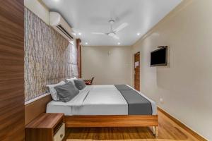 a bedroom with a bed and a tv on the wall at Upar Hotels Cinecity Kodambakkam RAGHAVENDRA MANDAPAM in Chennai