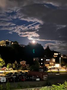 una vista de una ciudad por la noche con la luna en Dammyr, close to City with parking, en Fredrikstad