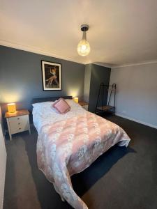 a bedroom with a large bed with a pink pillow at St Martin’s view in Haverfordwest