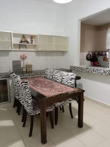 a dining room table with zebra chairs in a kitchen at Rumah Cikgu 3bilik tidur in Jitra