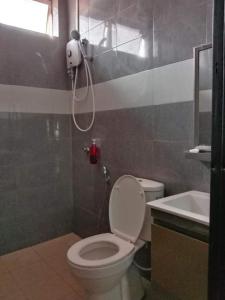 a bathroom with a shower and a toilet and a sink at Homestay Rumah Cikgu 3bilik tidur in Jitra