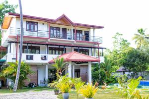 a large white house with a red roof at Shan Star Weligama in Weligama
