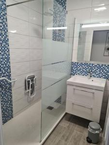 La salle de bains est pourvue d'une douche en verre et d'un lavabo. dans l'établissement LE COCON DE JADE, LA MER A PERTE DE VUE, au Havre