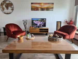 een woonkamer met 2 stoelen en een salontafel bij LE COCON DE JADE, LA MER A PERTE DE VUE in Le Havre