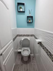 een badkamer met een toilet en een blauwe muur bij LE COCON DE JADE, LA MER A PERTE DE VUE in Le Havre