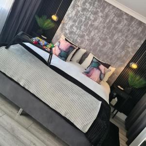 - une chambre avec un grand lit et des oreillers dans l'établissement Luxury 9ine SUPER BEAUTIFUL JACUZZI APARTMENT WITH BALCONY, à Birmingham