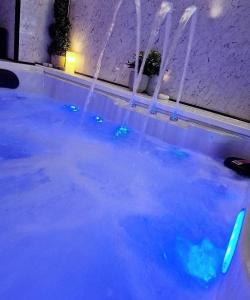 einen Pool mit blauem Wasser mit Lichtern darin in der Unterkunft Luxury 9ine SUPER BEAUTIFUL JACUZZI APARTMENT WITH BALCONY in Birmingham
