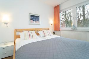 una camera bianca con un grande letto e due finestre di Haus Seestern Seestern 3 a Scharbeutz
