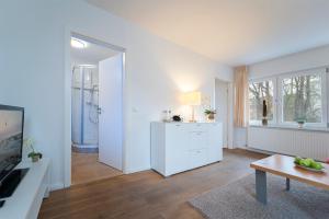 un soggiorno bianco con cucina e tavolo di Haus Seestern Seestern 3 a Scharbeutz