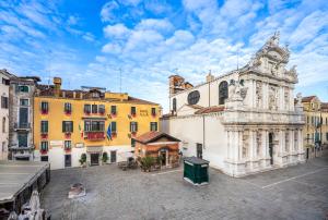 un groupe de bâtiments dans une ville dotée d'une tour d'horloge dans l'établissement UNAHOTELS Ala Venezia-Adults 16, à Venise