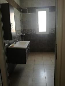 een badkamer met een wastafel en een raam bij s 2 1 km from the beach mansoura kelibia in Kelibia