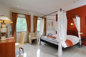 a bedroom with a canopy bed and a desk at Kasteel Wurfeld in Maaseik