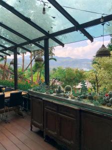 a patio with a bar with a view of the mountains at U Maerim Chiangmai - อยู่แม่ริม เชียงใหม่ in Mae Rim