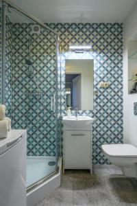羅茲的住宿－羅茲市中心租賃公寓，带淋浴、盥洗盆和镜子的浴室