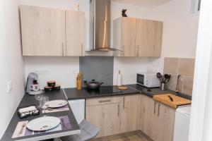 a kitchen with wooden cabinets and a counter top at La Mad Experience in Vernon